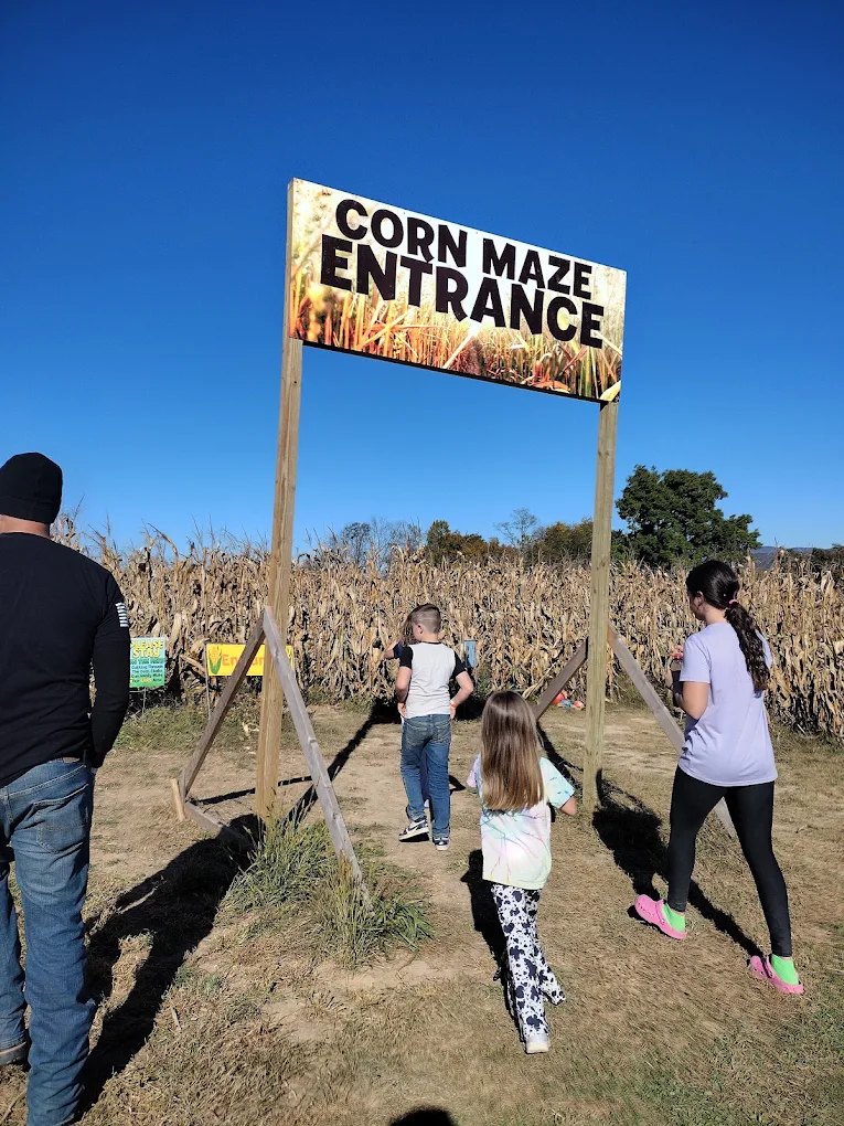 Families walking under the corn maze entrance sign at Endless View Farms